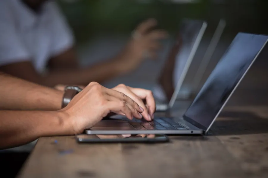 Writer typing on a laptop while researching a technology article