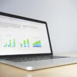 Laptop on a desk displaying colourful charts, illustrating how to choose a laptop