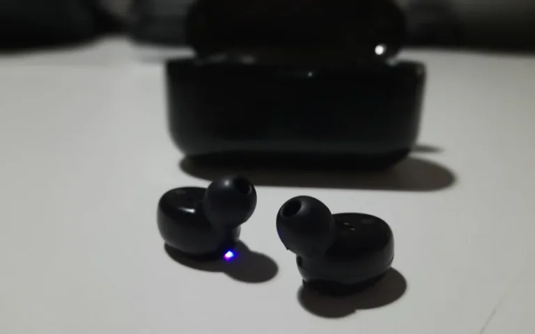 Pair of wireless earbuds next to their charging case