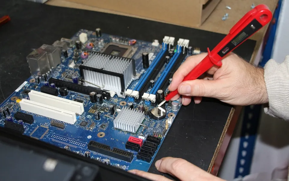 Technician repairing the inside of an electronic device with precision tools