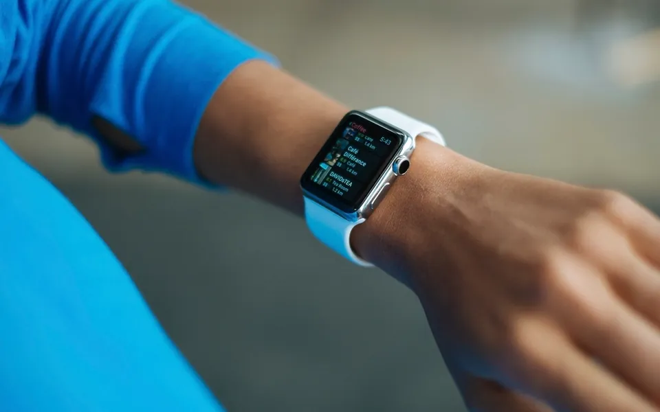 Smartwatch on a wrist showing fitness and notification screens